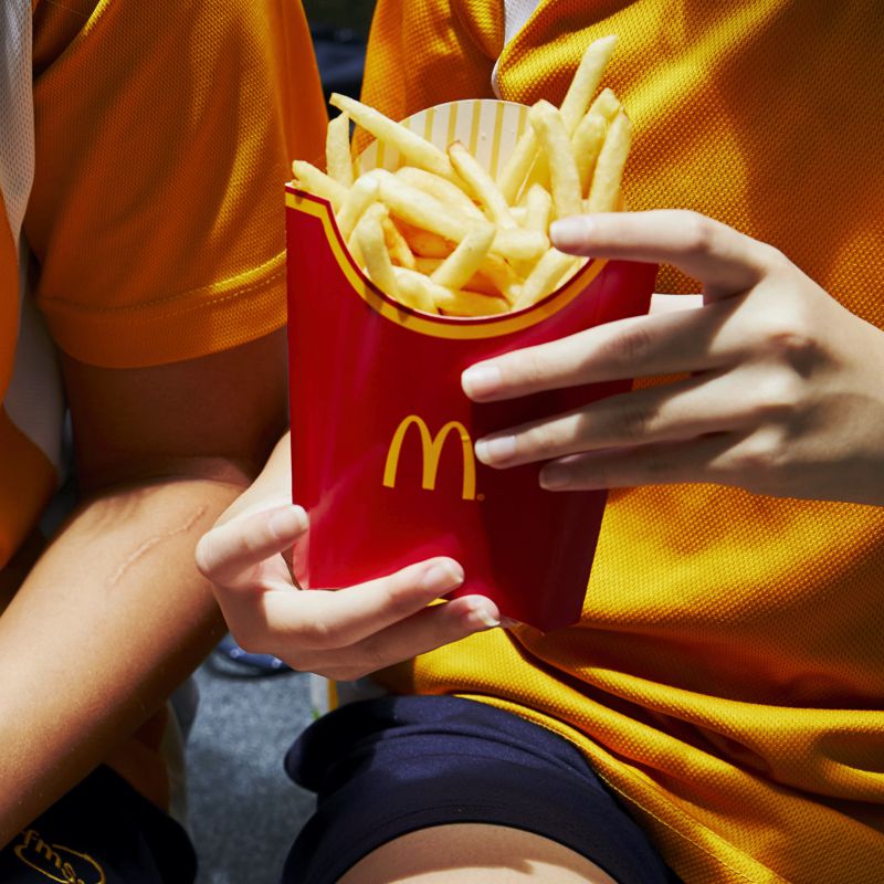Papas fritas de McDonalds en la mano de una niña